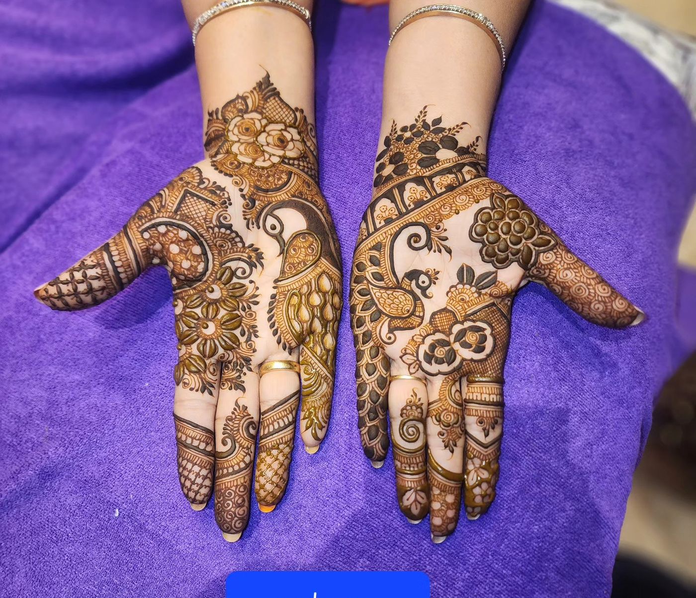 Bridal mehendi on hands resting on a green lehenga